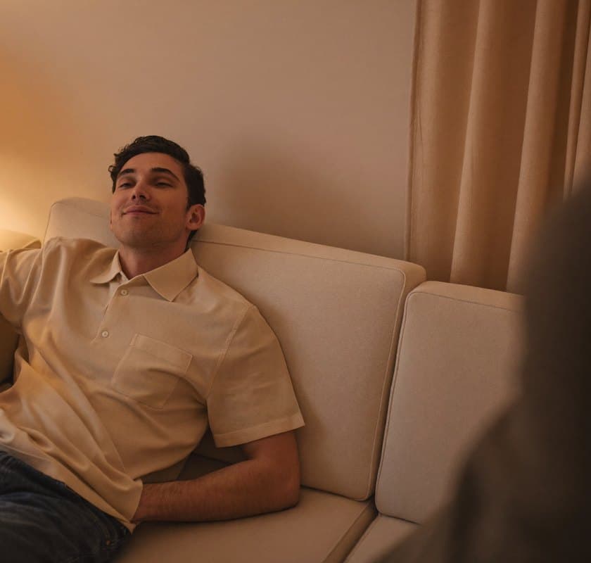 Man sitting relaxed on the sofa in warm evening lamp light